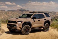 a tan toyota pickup truck parked on a dirt road