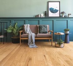 a living room with wood floors and green walls, including a couch in the corner