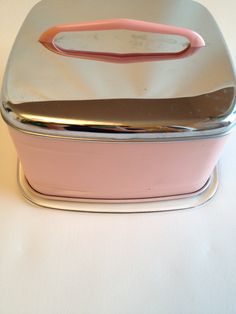 a pink and silver container sitting on top of a white table