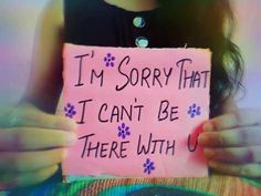 a girl holding a sign that says i'm sorry that i can't be there with u