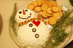 a frosted snowman cake with cookies and crackers