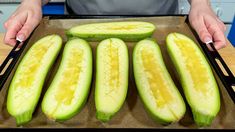 a person holding a tray with cucumbers cut in half and ready to eat