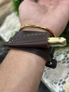 a man's hand with a leather wristband