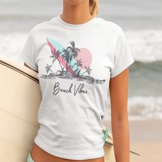 Get into the summer spirit with our Beach Vibes T-shirt featuring a stunning image of a beach, palm trees, and a surfboard. This graphic tee is perfect for those who love the ocean and all things beach-related. Made from high-quality materials, this t-shirt is comfortable to wear and will quickly become a favorite in your wardrobe. Whether you're planning a trip to the coast or just want to bring some beach vibes into your daily life, this shirt is the perfect choice. Makes a great gift for beach lovers and anyone who enjoys a touch of tropical paradise in their outfits. Order yours today and let the summer vibes wash over you! .: 100% Airlume combed and ringspun cotton (fiber content may vary for different colors) .: Light fabric (4.2 oz/yd² (142 g/m .: Retail fit .: Tear away label .: Ru Tropical Graphic Print T-shirt For Beach, White Tropical T-shirt For Beach Season, White Tropical Print T-shirt For Vacation, Beach T-shirt With Sublimation Print, White Hawaiian Surfing Top, White Tropical Surfing Top, Tropical Print T-shirt For Vacation, White Tropical Print T-shirt For Summer, Tropical Print T-shirt For Beach Season