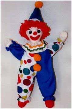 a clown doll with red hair and blue pants is hanging on the wall in front of a white background