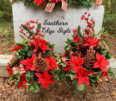 two vases filled with red poinsettias and pine cones are sitting in front of a sign that says southern edge style