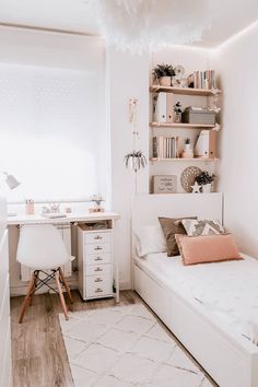 a white room with a bed, desk and shelves filled with books on the wall