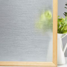 a potted plant sitting in front of a mirror on top of a white table