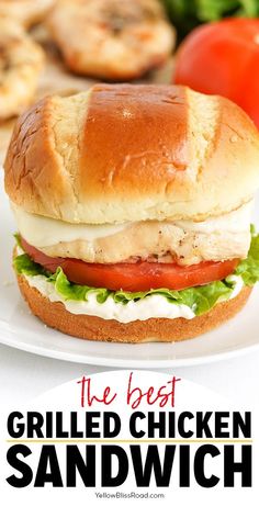 the best grilled chicken sandwich recipe on a white plate with tomatoes and lettuce