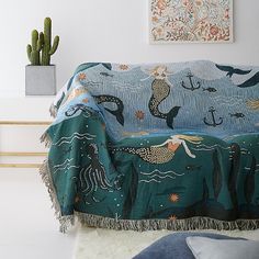 a living room with a couch covered in a blue blanket and sea animals on it