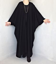 "This black long kimono is perfect for so many occasions! It is an oversized maxi poncho is made of soft flowy cotton blend fabric. You can use this kimono dressing gown every day both indoors or outdoors. The summer kimono cardigan is very loose, and it suitable for all body forms and shapes. Also, it can wear as a boho beach cover-up in summer. You will look fabulous when you wear this summer poncho top. This long cloak would be a perfect gift for you or your loved ones. The plus-size kimono r Bohemian Long Black Robe, Bohemian Black Long Robe, Oversized Long Sleeve Black Abaya, Oversized Black Long Sleeve Abaya, Black Long Bohemian Robe, Long Black Bohemian Robe, Oversized Black Abaya, Elegant Oversized Black Cape, Elegant Black Oversized Cape