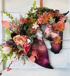 a horse head decorated with flowers and greenery hangs on the wall in front of a door