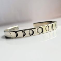 "German Silver or Solid Sterling Silver cuff bracelet deep engraved with moon phases as seen in photos. - 1/4\" x 6\" cuff with open back - personalize it by adding a secret message to the inside - all cuffs can be adjusted with steady pressure to be made tighter or looser CHECK OUT MY ENTIRE SHOP! https://www.etsy.com/shop/TatumBradleyCo?ref=si_shop" Adjustable Silver Moon Bracelet, Silver Moon Shaped Adjustable Bracelet, Adjustable Silver Moon Bracelets, Adjustable Silver Moon-shaped Bracelets, Adjustable Etched Round Cuff Bracelet, Adjustable Etched Cuff Bracelet, Adjustable Engraved Moon-shaped Jewelry, Adjustable Engraved Moon Jewelry, Adjustable Sterling Silver Moon Phase Bracelet