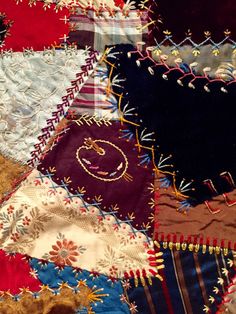 a close up of many different colored pieces of cloth on a tablecloth that has been stitched together