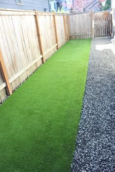 a backyard with grass and gravel in the middle