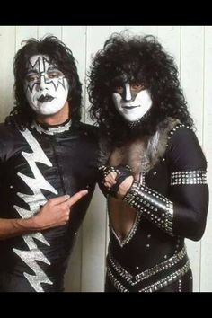 two men dressed in black and white are posing for the camera with their faces painted