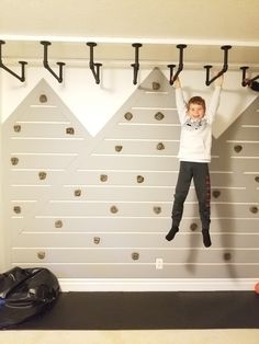 a young boy is hanging upside down on the wall