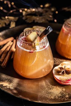 two glasses of apple cider with cinnamon sticks