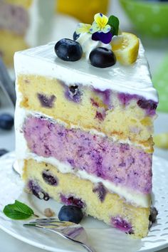 a slice of cake with blueberries and lemon on top