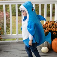 a little boy dressed in a shark costume