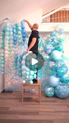 a man is standing on a chair in front of balloons