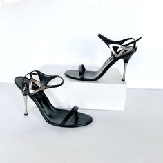 Black Leather Sandals With Silver Tone Heel And Silver Detail At Side 4.25 " Heel Come With Dust Bag Excellent Condition Open Toe Evening Heels With Metal Feet, Open Toe Heels With Metal Feet For Evening, Evening Open Toe Heels With Metal Feet, Luxury Open Toe Heels With Metal Feet, Formal Sandals With Metal Feet And Open Heel, Silver Sandals With Sculpted Heel For Cocktail, Modern Heels With Metal Feet For Party, Modern Silver Heels With Buckle Closure, Modern Party Heels With Metal Feet