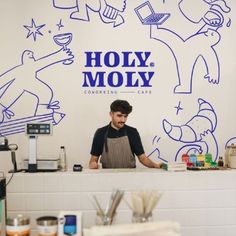 a man standing behind a counter in front of a wall