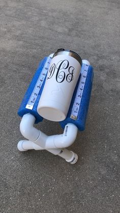 a white and blue water bottle sitting on the ground