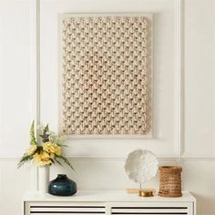 a white cabinet with two vases and a painting on the wall