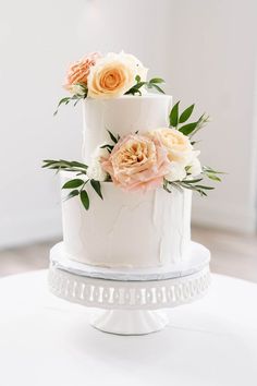 a three tiered white cake with flowers on top