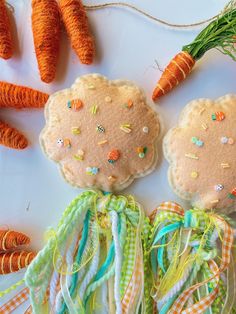 some carrots are laying next to each other on a table with ribbons and thread