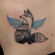 a tattoo on the back of a woman's chest with an image of a fox