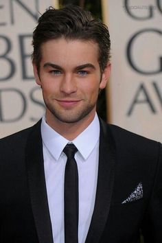 a young man in a suit and tie posing for the camera at an awards event