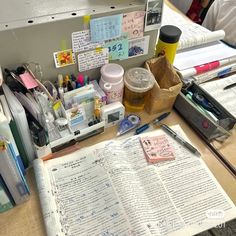 an open book sitting on top of a desk next to other office supplies and papers