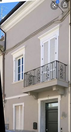 an apartment building with white shutters and balconies