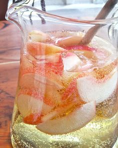 a pitcher filled with ice and fruit on top of a table