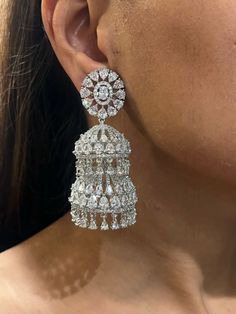 Introducing our **Exquisite American Diamond Jhumka Earrings** - a perfect blend of timeless elegance and sparkling sophistication. These stunning earrings feature meticulously crafted American diamonds that capture and reflect light, creating a dazzling effect. The traditional Jhumka design is enhanced with a modern twist, making these earrings a versatile accessory for any occasion, from festive celebrations to elegant soirées. Lightweight and comfortable, they offer enduring beauty and qualit Luxury American Diamond Bridal Earrings For Diwali, Luxury Fusion Style American Diamond Jhumkas, Elegant Cubic Zirconia Jhumkas With Intricate Design, Elegant Jhumkas With Intricate Design In Cubic Zirconia, Elegant Cubic Zirconia Jhumkas For Festive Occasions, Elegant Round Cubic Zirconia Jhumkas, Elegant Cubic Zirconia Jhumkas, Elegant Formal Festive Jhumkas, Round Danglers For Formal Festive Occasions