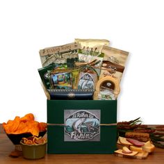 a green box filled with assorted food and snacks on top of a wooden table