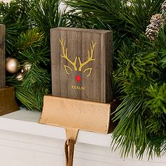 two wooden boxes with reindeer heads on them are sitting on a mantel in front of christmas decorations