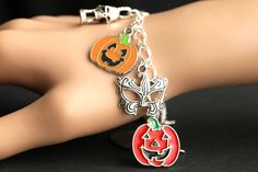 A collection of silver plated Halloween themed charms combined with five enameled Jack o'Lantern charms have been dispersed around a shimmering silver plated bracelet chain in this handmade charm bracelet. This Halloween charm bracelet is then completed with a lobster clasp and a 1/2 inch of chain at the end for adjustable sizing. Charms in this bracelet include five enameled jack o' lantern charms, haunted house charm, grim reaper charm, masquerade mask charm, and screaming skull charm. I also Silver Metal Jewelry For Costume Party, Halloween Novelty Jewelry Bracelet, Halloween Novelty Bracelet, Silver Novelty Bracelets For Party, Novelty Silver Halloween Bracelet, Novelty Silver Bracelet For Halloween, Silver Halloween Novelty Bracelet, Halloween Bracelet Jewelry Gift, Halloween Themed Silver Bracelet