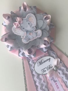 an elephant is sitting on top of some pink and gray paper with the words mommy to be