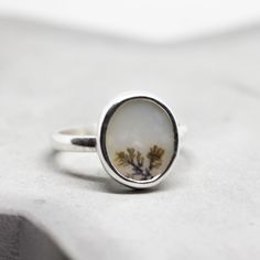 The listing is for one ring with Dendritic Agate stone. These Agates are colourless, white, or grey, and have a tree- or fern-like inclusions of iron or manganese, called dendrites. The ring band is 2 mm thick and is very sturdy. You can order a ring of any size. If you don't see your size in the menu (or don't know your US ring size), pick any and send me a note with the size you want. If you are not sure about your size, this might be helpful: findmyringsize.com If you want to buy the ring as Nature-inspired Agate Rings With Natural Inclusions, White Oval Rings With Natural Inclusions, Nature-inspired Oval Rings Untreated, Nature-inspired Untreated Oval Rings, White Agate Rings With Natural Stones, Fall Closet, Dendritic Agate, Agate Ring, Ring Unique