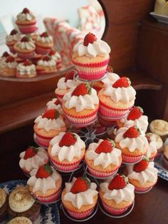 a tower of cupcakes with strawberries on top