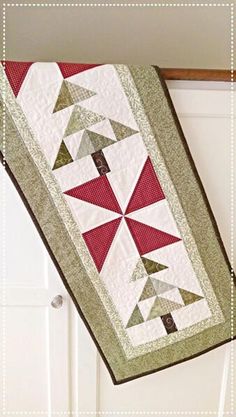 a red and white quilt hanging from the side of a door with an arrow on it