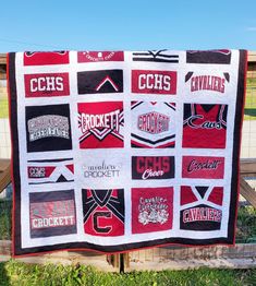 a quilt is hanging on a fence in front of some grass and dirt, with the words crickett written across it