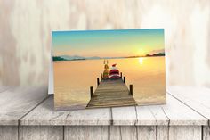 a greeting card with a boat on the water and a sunset in the back ground