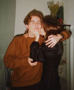 two people standing next to each other with their hands on their face and one person covering his mouth