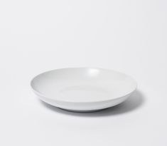 an empty white plate sitting on top of a table