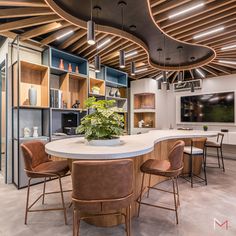 a large kitchen with an island in the center surrounded by chairs and shelves filled with vases