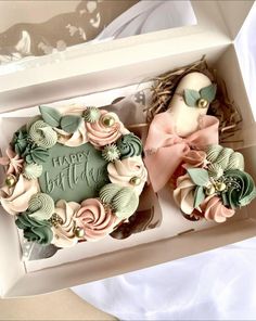 two cupcakes in a box decorated with flowers